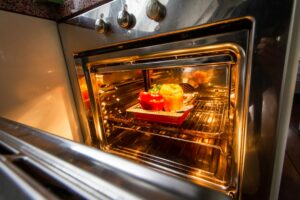 Teglie con pietanze all’interno di un forno domestico