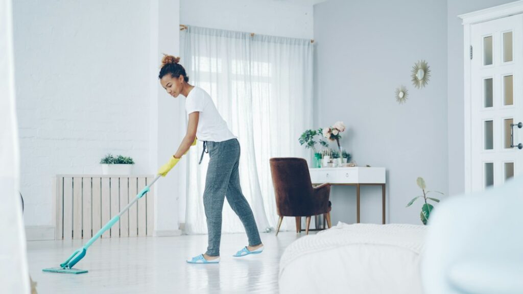 Persona che lava il pavimento con un mop in microfibra per rimuovere residui appiccicosi