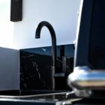 Lavello da cucina scuro in materiale composito con rubinetto nero