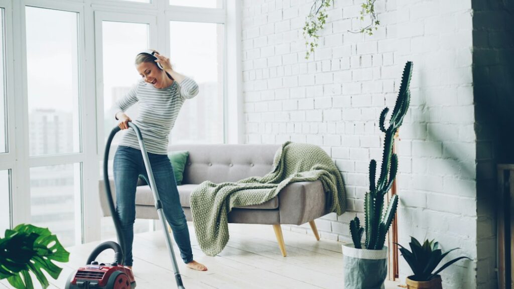 Persona che pulisce il pavimento di casa con un aspirapolvere