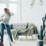 Persona che pulisce il pavimento di casa con un aspirapolvere