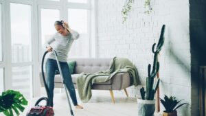 Persona che pulisce il pavimento di casa con un aspirapolvere